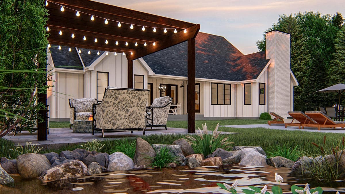 Modern Farmhouse house plan exterior with white board-and-batten siding, large brick chimney, and covered patio with string lights.