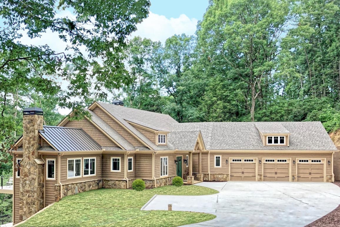 House plan exterior. Two-story home with Craftsman influence. Features include a stone chimney, shed and gable rooflines, and a three-car garage.