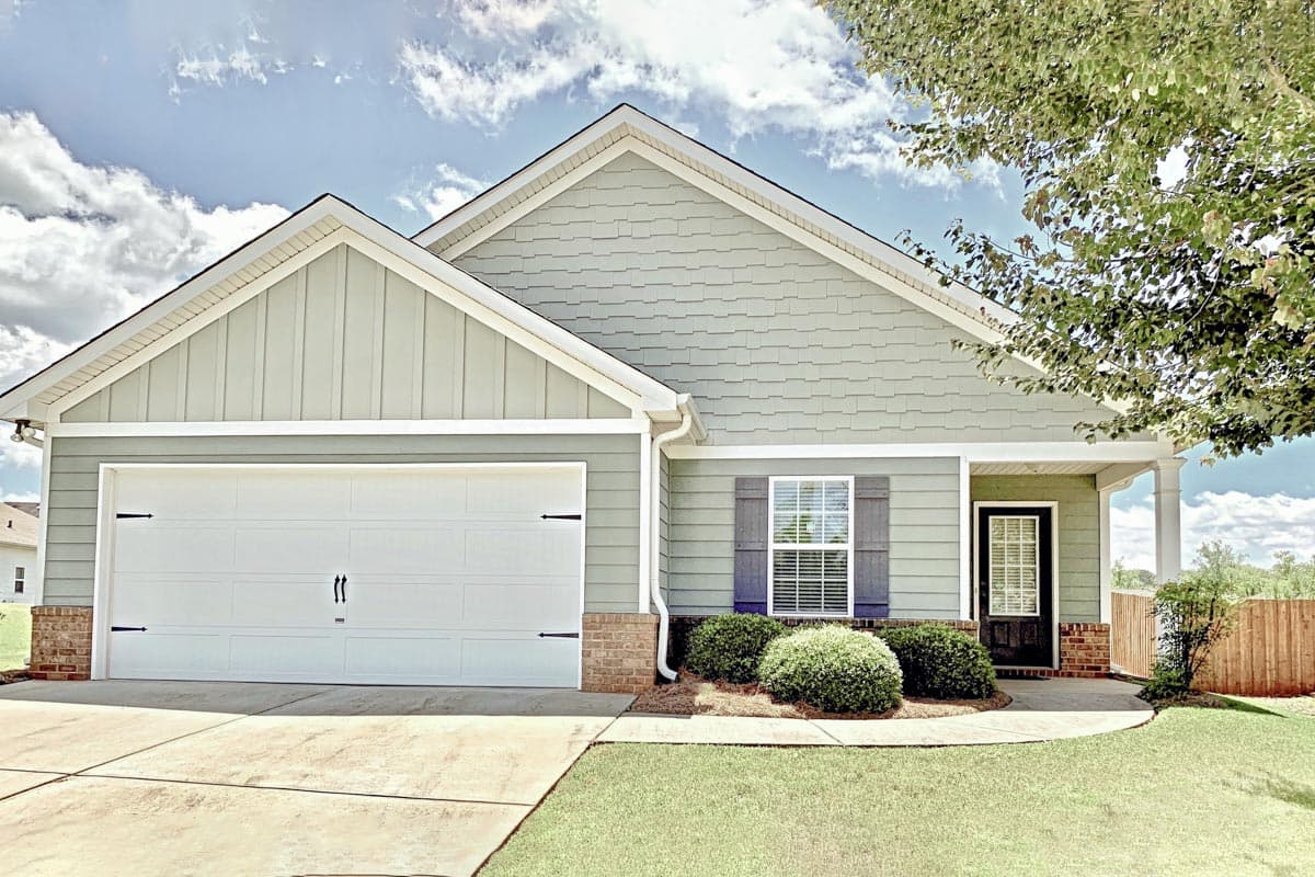 House plan exterior with Craftsman-style elements. Features include a front-facing garage, gabled roof, and covered front porch.