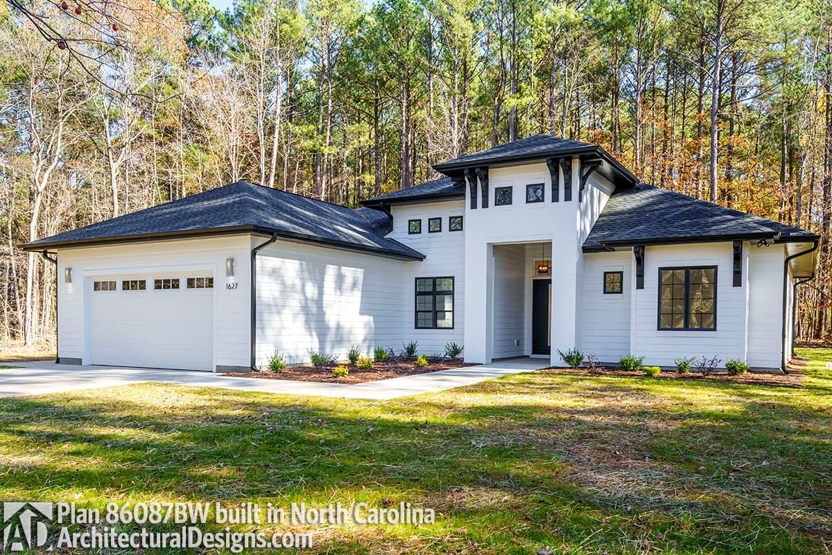 House plan exterior: One-story Modern Farmhouse with attached garage, prominent gables, and decorative brackets.
