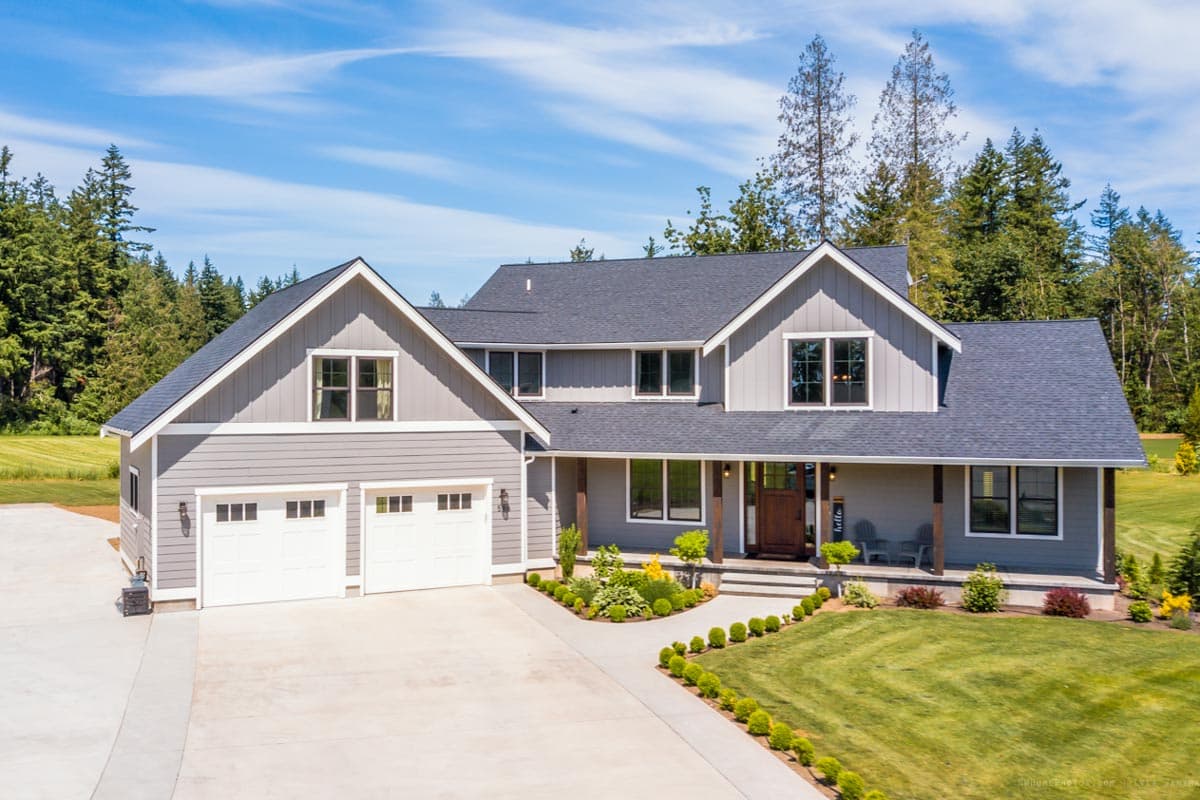 House plan exterior: Modern Farmhouse style, two stories, with a front-facing gable, covered porch, and a three-car garage.