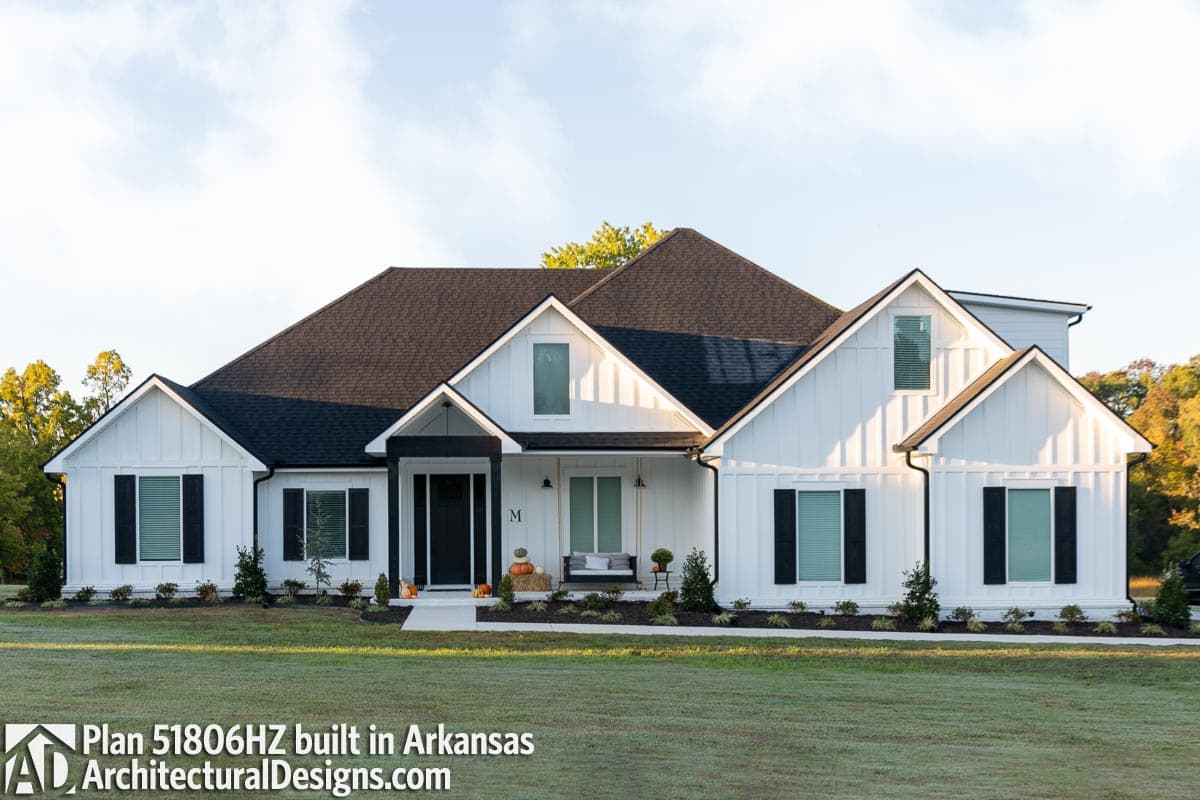 Modern Farmhouse style house plan exterior with white board-and-batten siding, gables, and covered front porch.