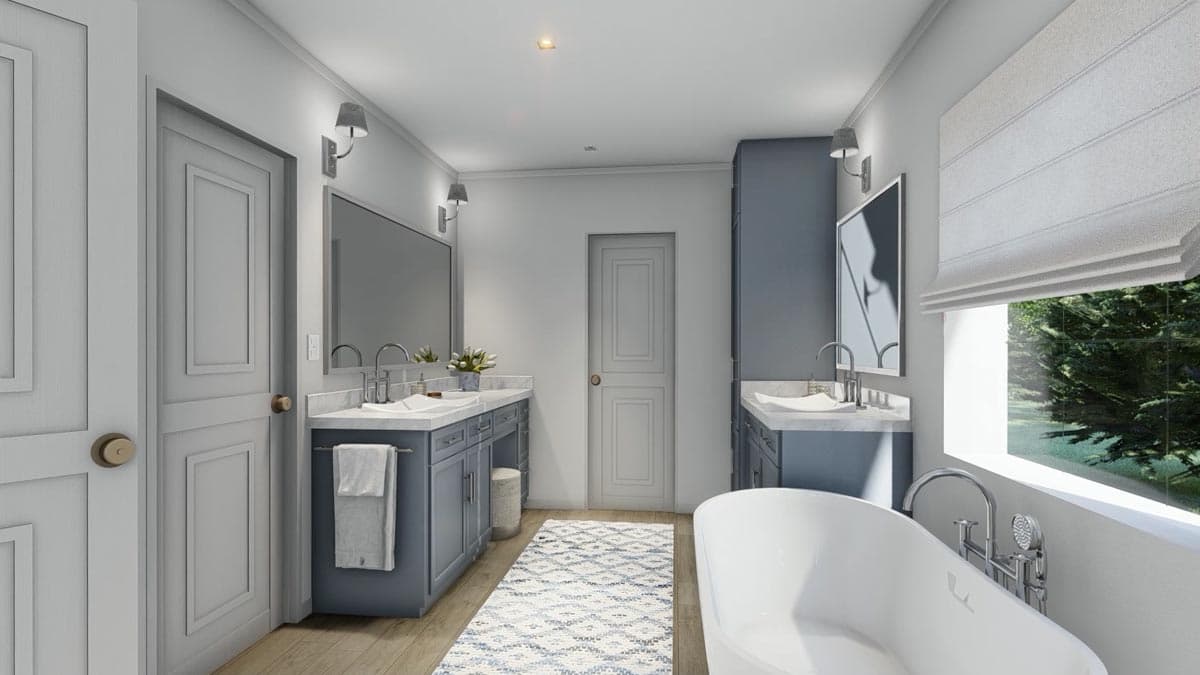 A modern master bathroom with two vanities, a free-standing tub, and a window with a view of trees. The walls are light grey.