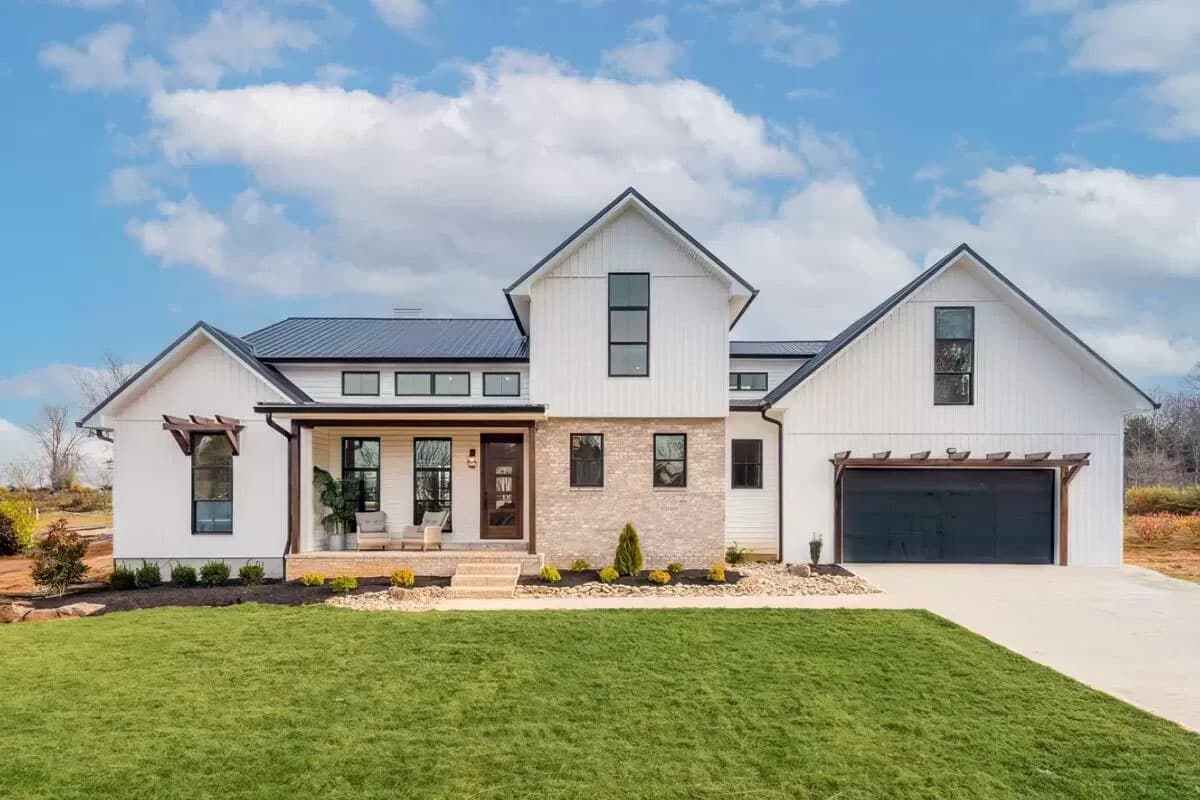 House plan exterior. Two-story Modern Farmhouse with gabled rooflines, a front porch, and an attached garage with a dark-colored door.