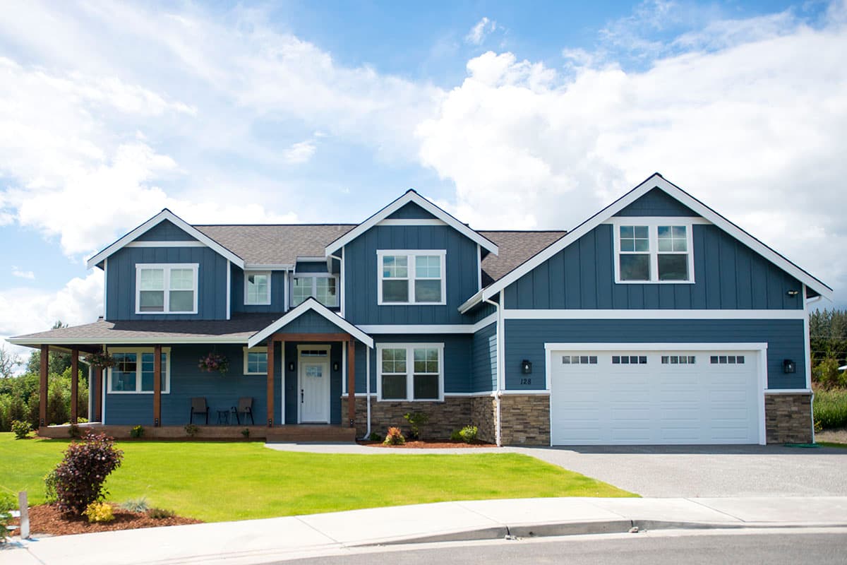 House plan exterior with two stories, Craftsman style. Features include gabled roof, covered porch, and attached garage.