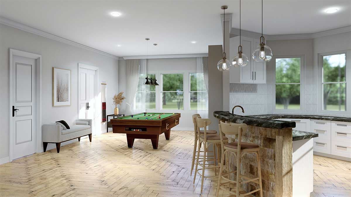Interior view of a home showing a pool table and a kitchen island with bar stools. Herringbone wood floors are visible.