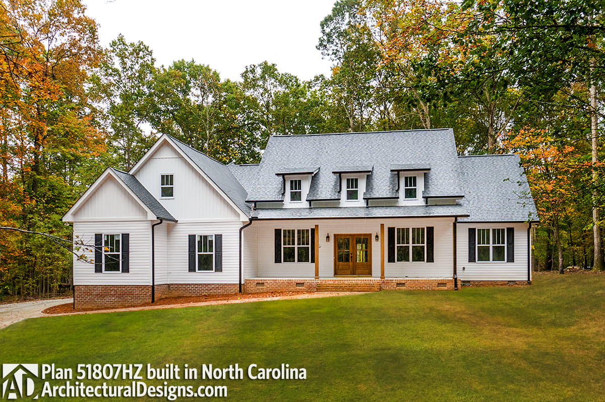 House plan exterior: White Modern Farmhouse with gables, dormers, prominent porch, and board and batten siding.