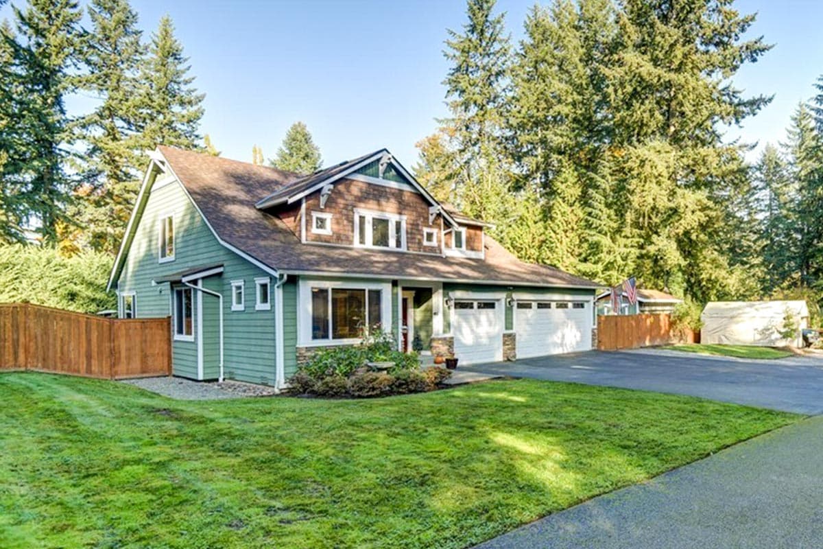 House plan exterior: Two-story home with green siding, dormers, gables, and a three-car garage.
