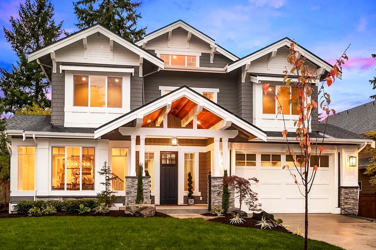 House plan exterior. Two-story Craftsman home with gabled rooflines, a covered porch, and a two-car garage. Features include decorative brackets.