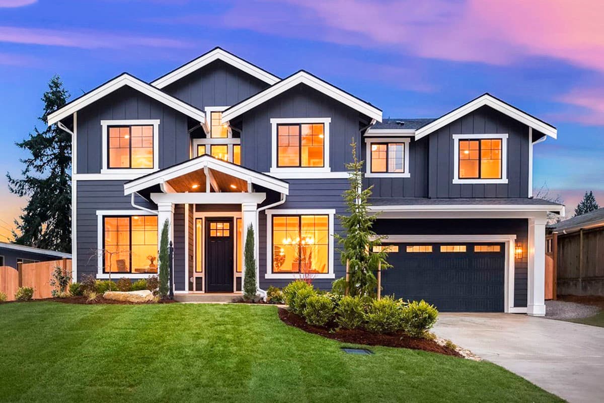 House plan exterior. Two-story home with a gabled roof, a front porch with columns, and a garage with a carriage-style door.
