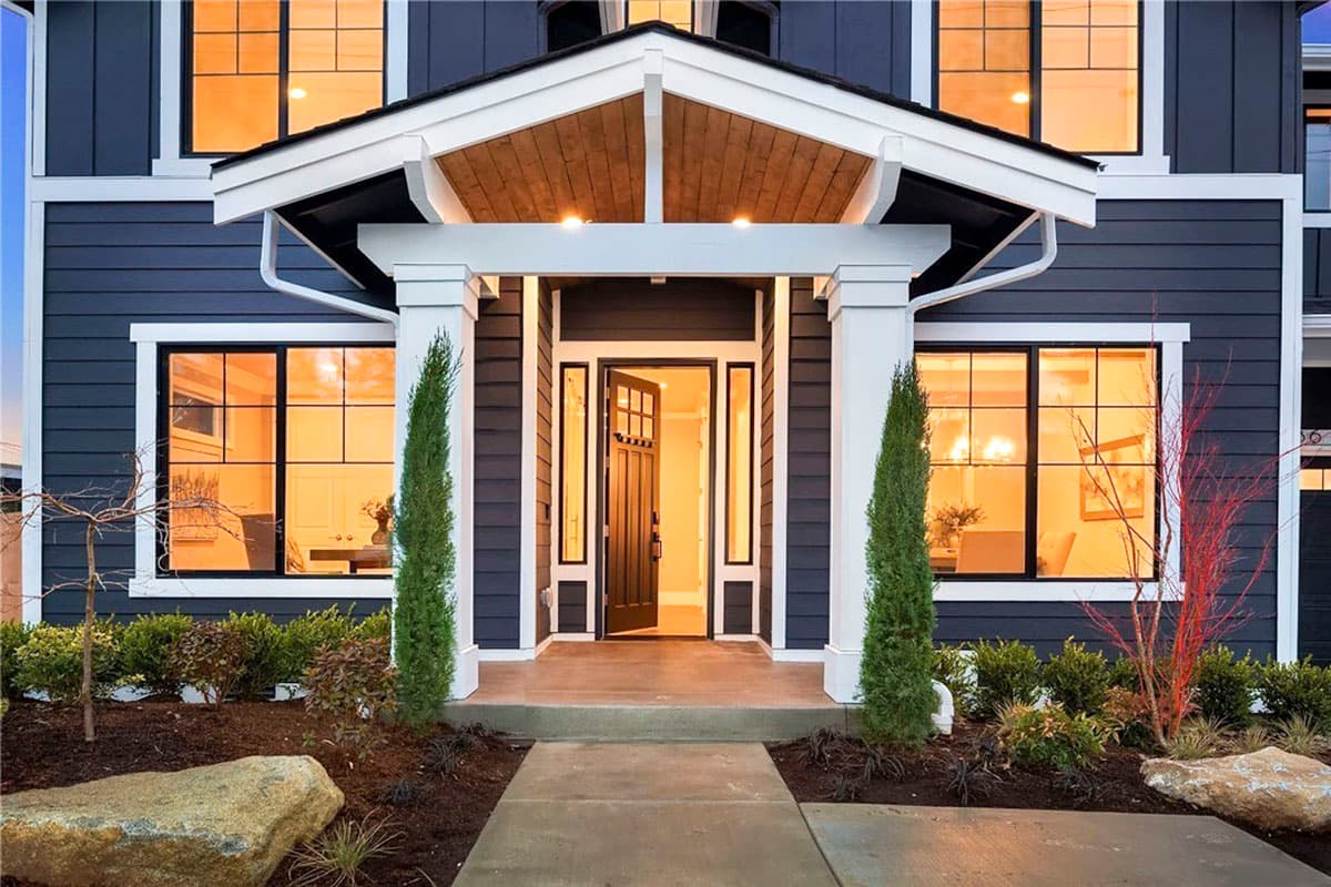 Modern Farmhouse house plan exterior with covered entry, gabled roof, multiple windows, and dark siding.