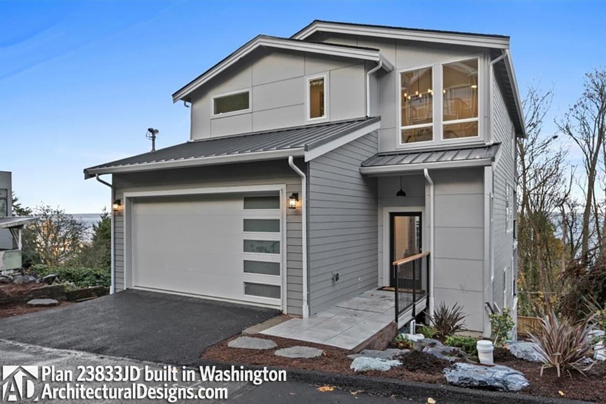 Modern style two-story house plan exterior with attached garage, sloped rooflines, and large front windows.