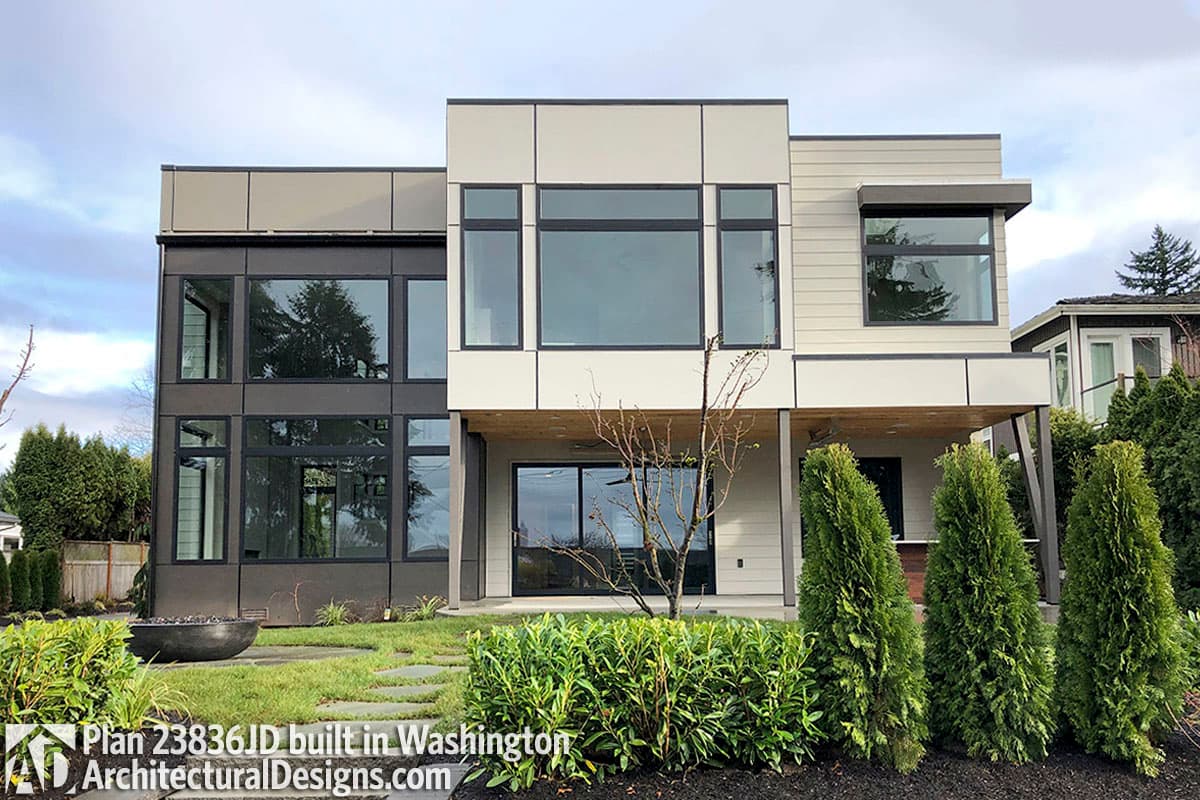 Modern house plan exterior featuring multiple stories, extensive glass, and cantilevered overhangs.