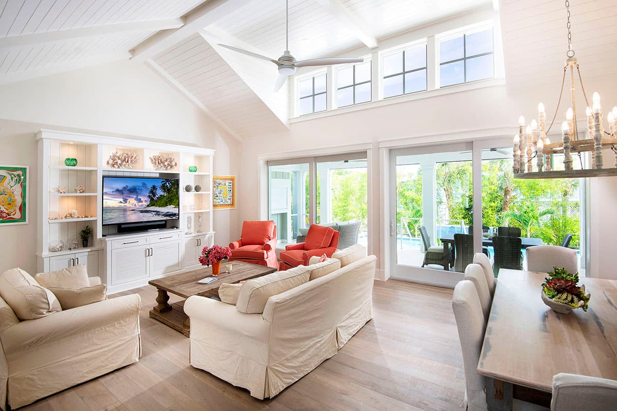 Great room with vaulted ceiling, built-in entertainment center, and sliding glass doors to outdoor living space.