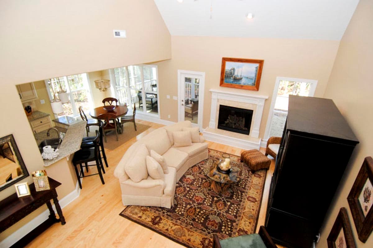 Open-concept living area with fireplace, dining nook, and kitchen island with bar seating.