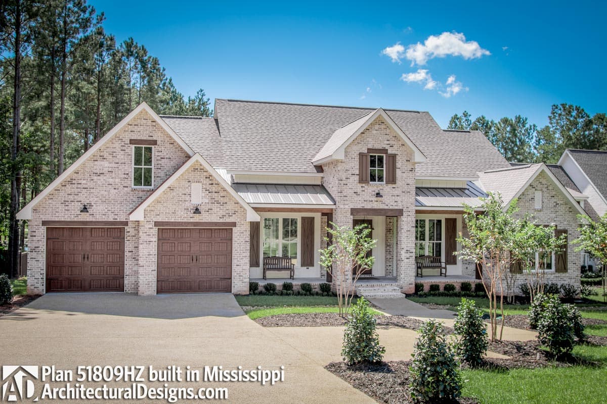 House plan exterior: Modern Farmhouse style, one story, with triple garage, covered front porch, and multiple gables.