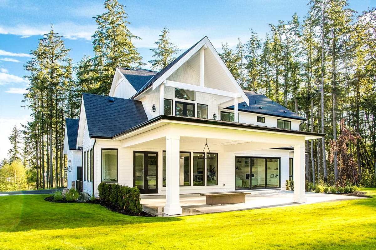Modern Farmhouse house plan exterior with a covered porch, multiple gables, and large windows.