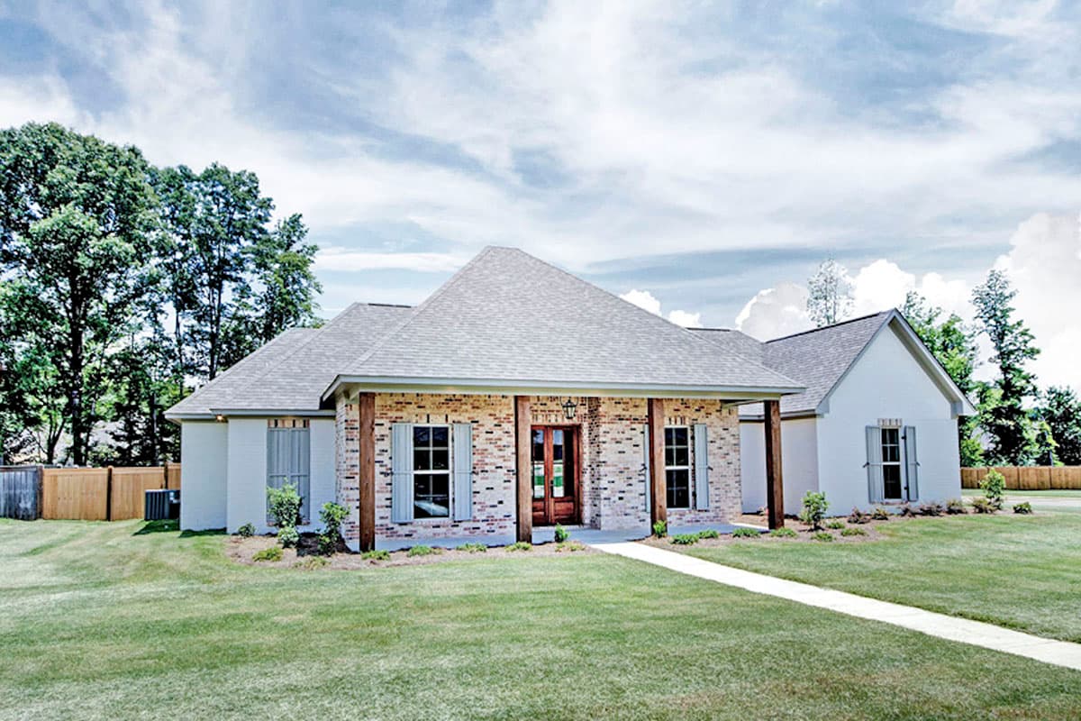 House plan exterior: one-story home with brick accents, covered front porch with wooden posts, and gable rooflines.