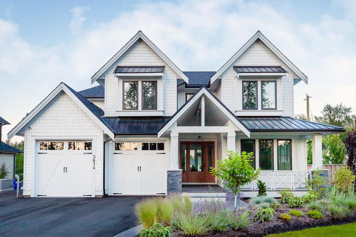 House plan exterior: Modern Farmhouse style, two stories, two garages, prominent gables, metal roof accents, and covered entry.
