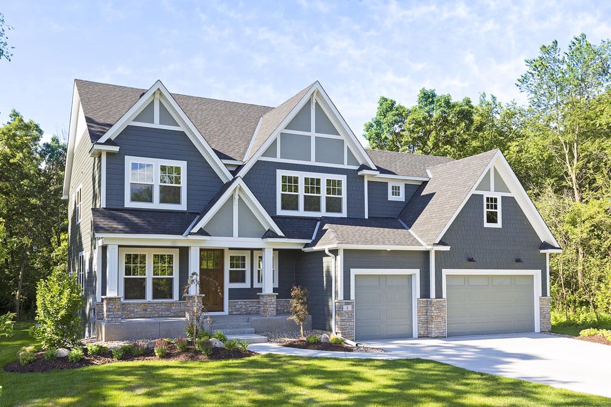 House plan exterior. Two-story Modern Farmhouse with gabled roof, front porch, and attached two-car garage. Features include board and batten siding.
