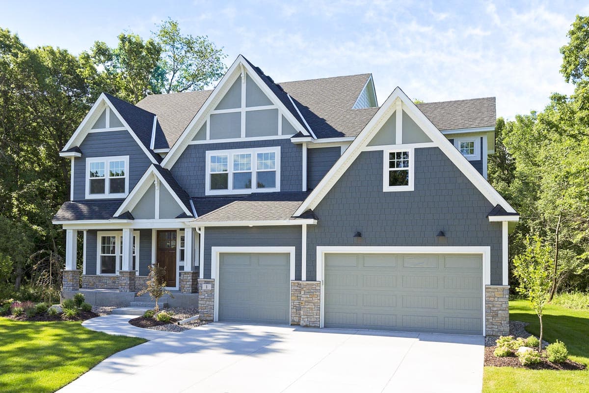 Modern Farmhouse house plan exterior, two stories, covered front porch, dual garage doors, stacked stone accents, and prominent gables.