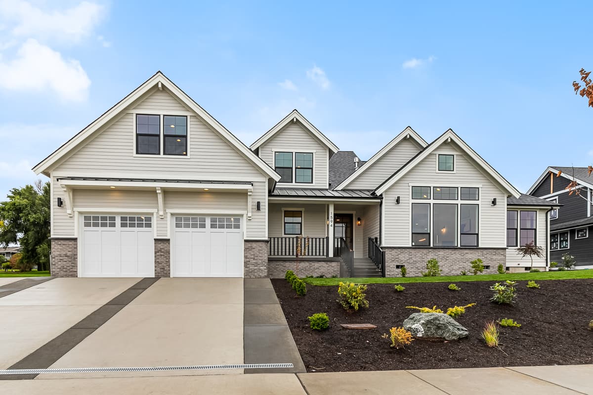 House plan exterior. Two-story home with Craftsman-style elements. Features include a front-facing garage, gables, and a covered porch.