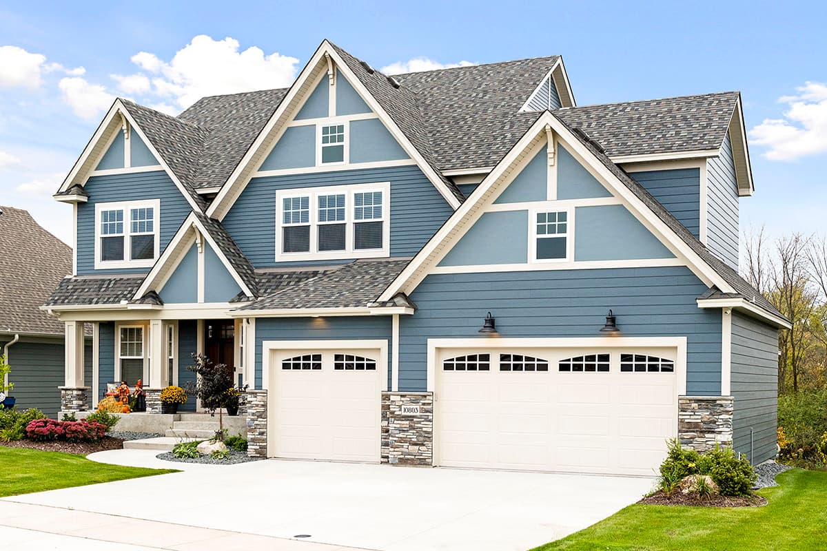 Two-story Modern Farmhouse style house plan exterior with two-car garage, stone accents, and multiple gables.