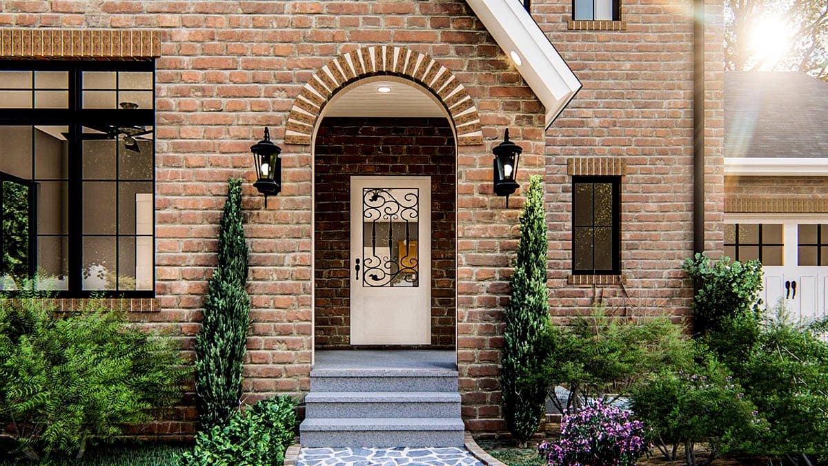 House plan exterior features arched entryway with decorative door, brick facade, multiple windows, and pitched roofline.