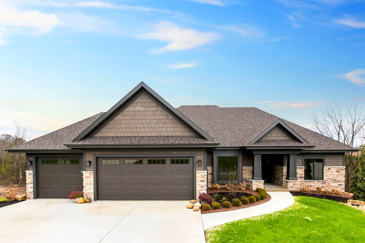 House plan exterior. Ranch style, single story. Features include multiple gables, a covered porch, and a three-car garage.