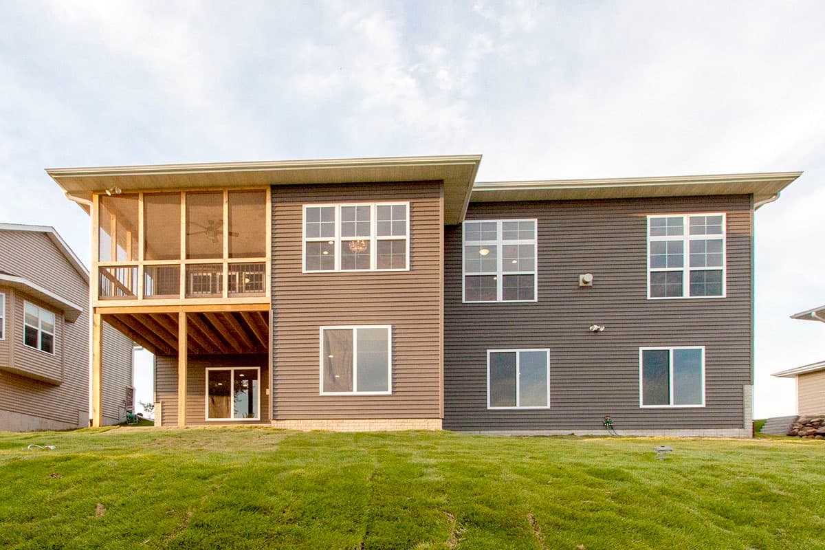 Two-story house plan exterior with a screened porch, large windows, and horizontal siding.