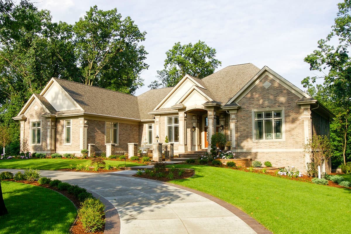 House plan exterior: One-story brick home with a covered entry, gables, and multiple rooflines.