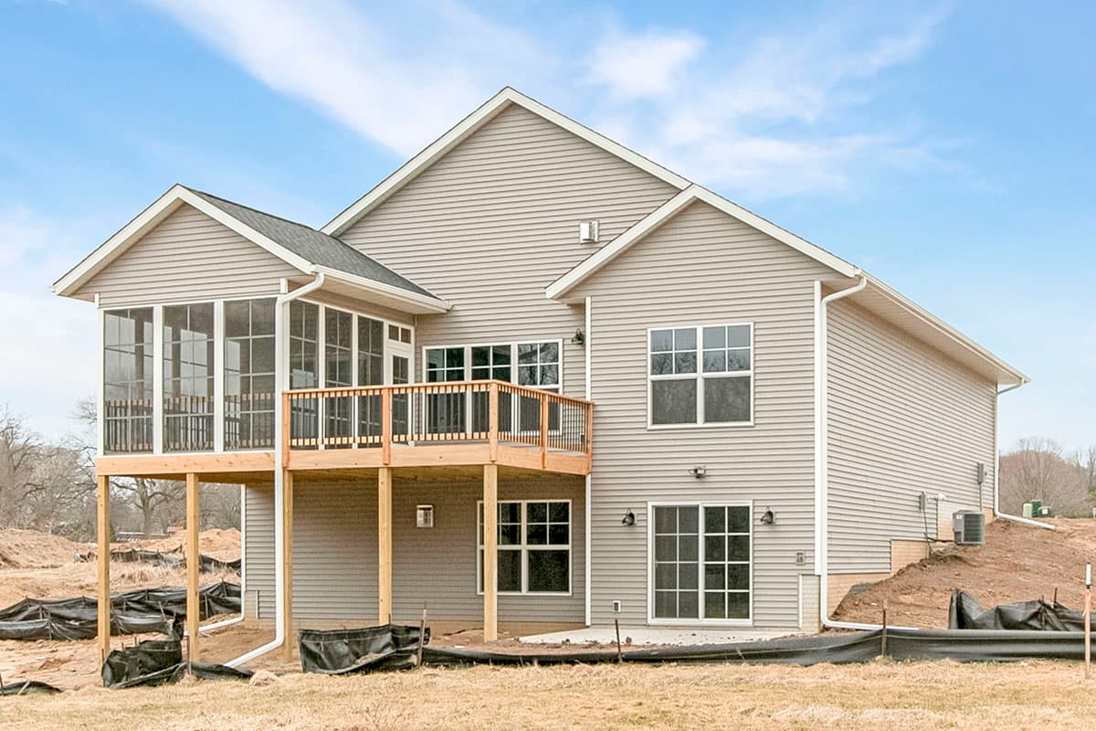 House plan exterior with screened porch, upper deck, and multiple gabled dormers on a two-story structure.