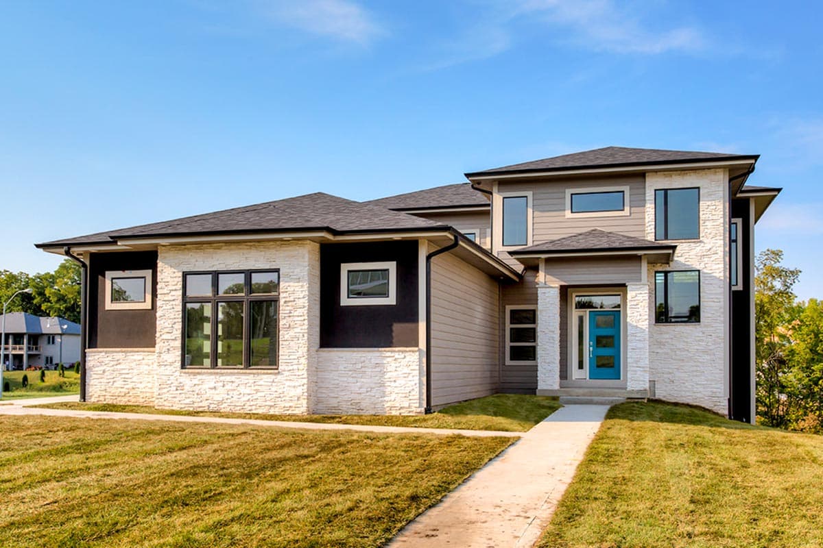 Modern two-story house plan exterior with stacked stone accents, horizontal siding, multiple gables, and a bright blue front door.