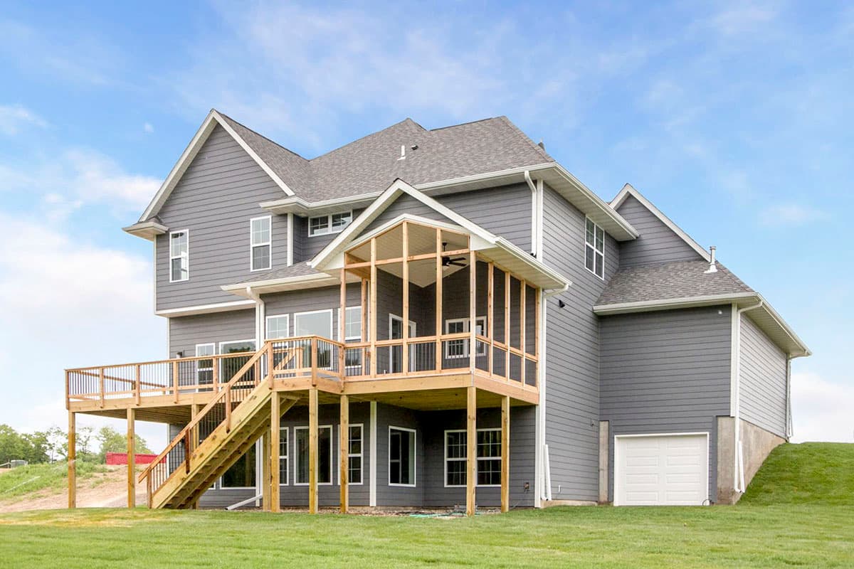 Two-story house plan exterior with siding, wraparound deck, screened porch, and side-entry garage.
