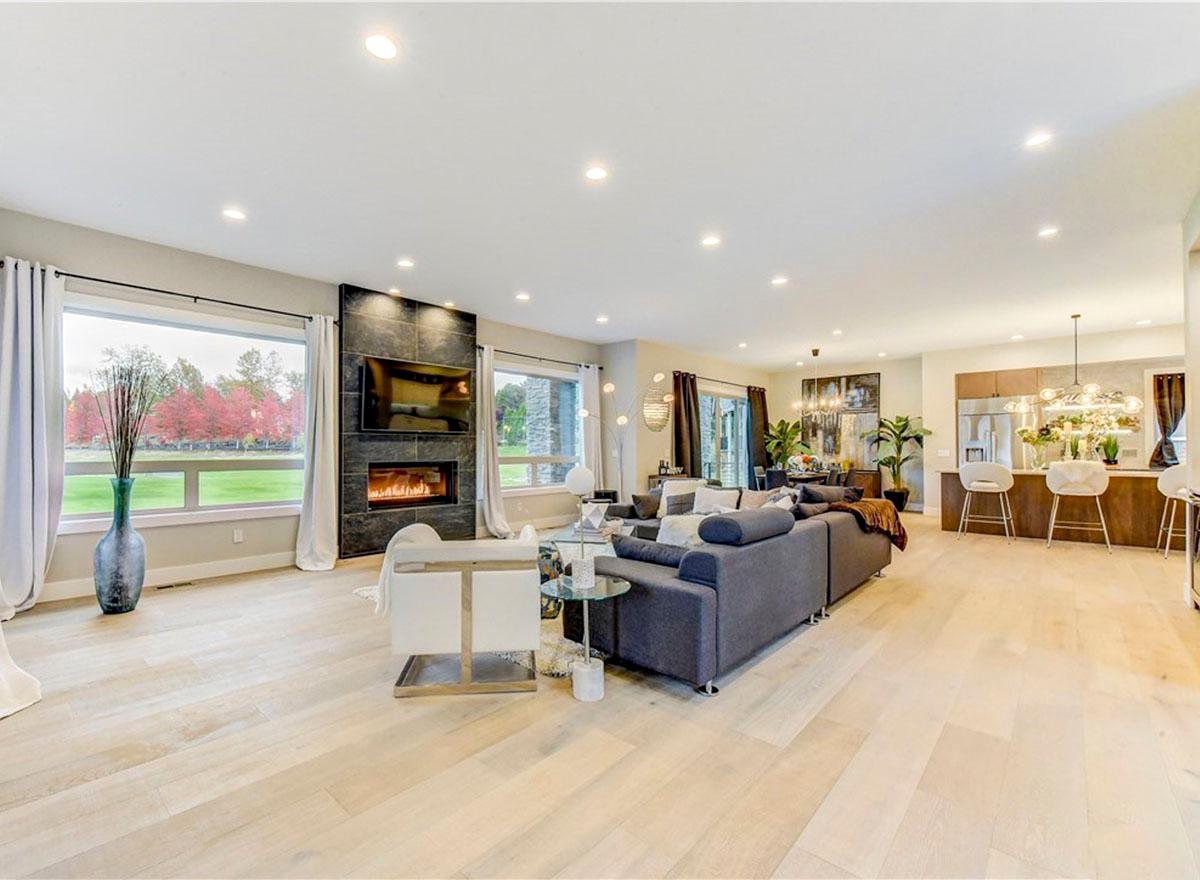 Open-concept living space with fireplace, sectional sofa, and kitchen island with bar seating.