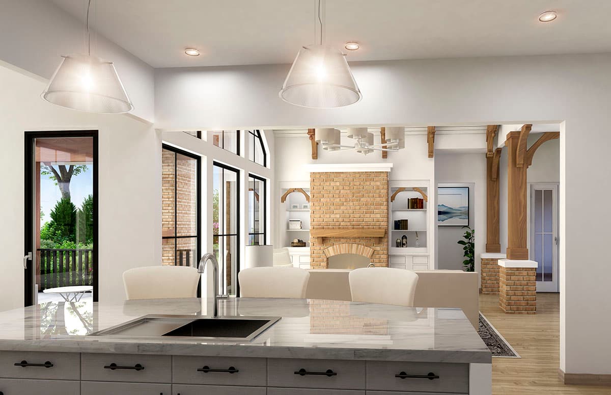 Open concept living area with a kitchen island, brick fireplace, and exposed wood beams.
