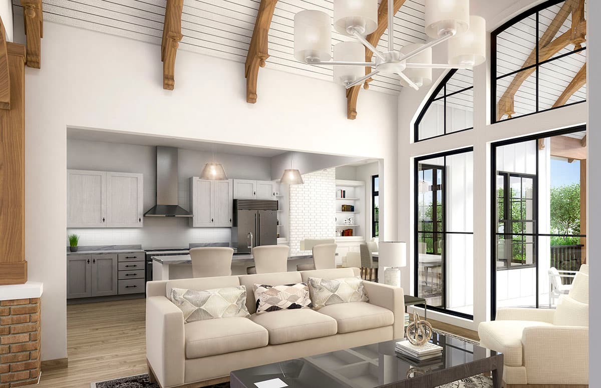 Open concept living area with vaulted beamed ceiling, large windows, and adjacent kitchen with island.