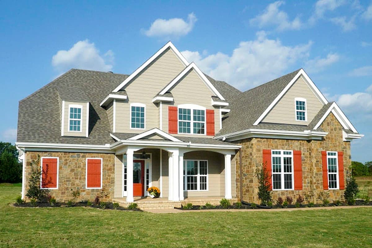 House plan exterior. Two-story home with stone accents, gabled roof, and covered front porch with columns. Red shutters are featured.