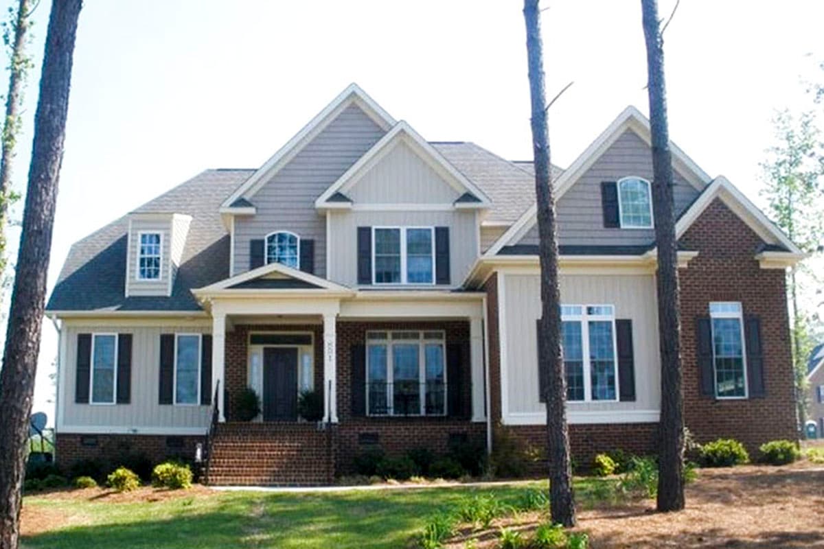 House plan exterior with brick and vinyl siding, prominent gables, dormers, and covered porch.