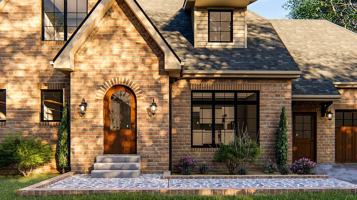 House plan exterior with arched entryway, brick facade, dormer window, and multiple gables.