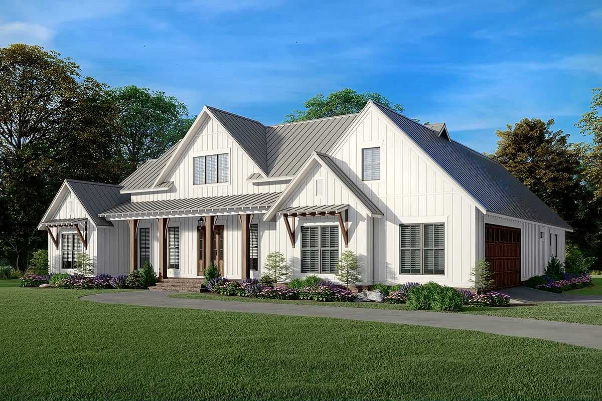 A modern farmhouse with white siding, a gray metal roof, and wooden porch supports, set against a green lawn and clear blue sky.