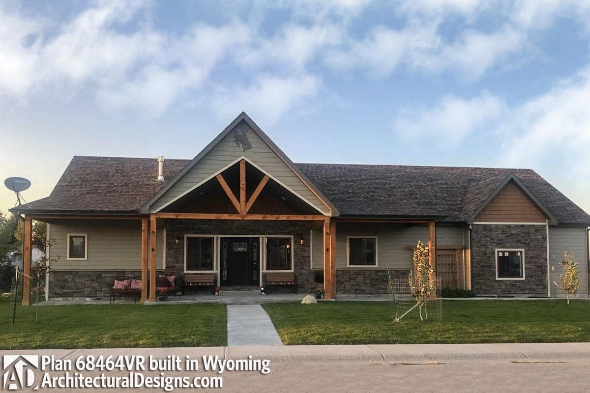 House plan exterior. Ranch-style home with a front porch, gables, and stone veneer accents. Features a covered entry and a low-pitched roof.