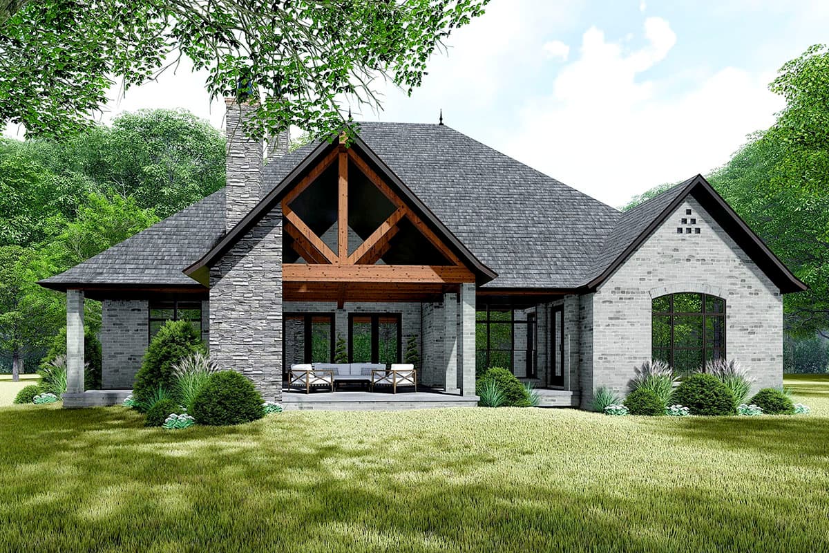House plan exterior showing a single-story home with stone chimney, exposed timber beams on covered porch, and arched window.