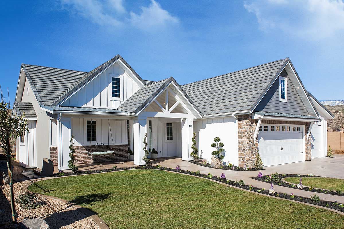 Modern Farmhouse style house plan exterior with gables, stone accents, covered porch with swing, and attached garage.
