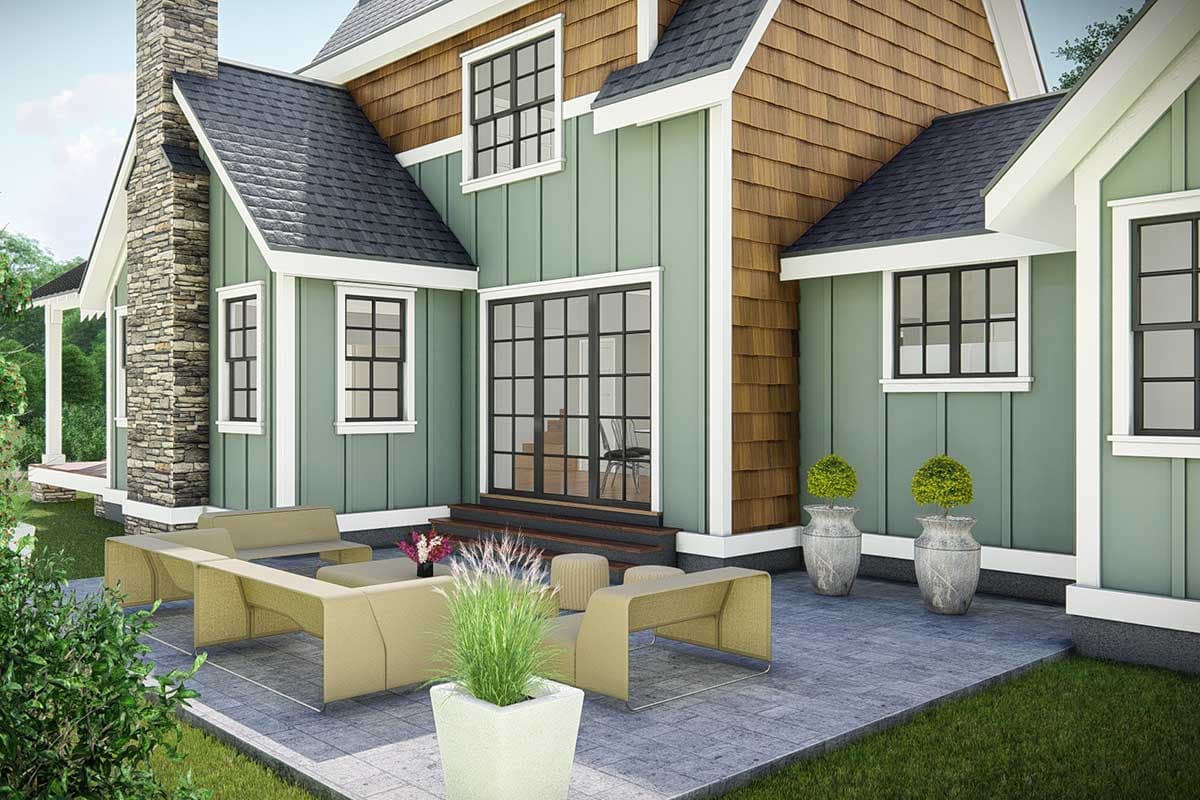 House plan exterior featuring stone chimney, board and batten siding, cedar shakes, and double glass doors leading to patio.