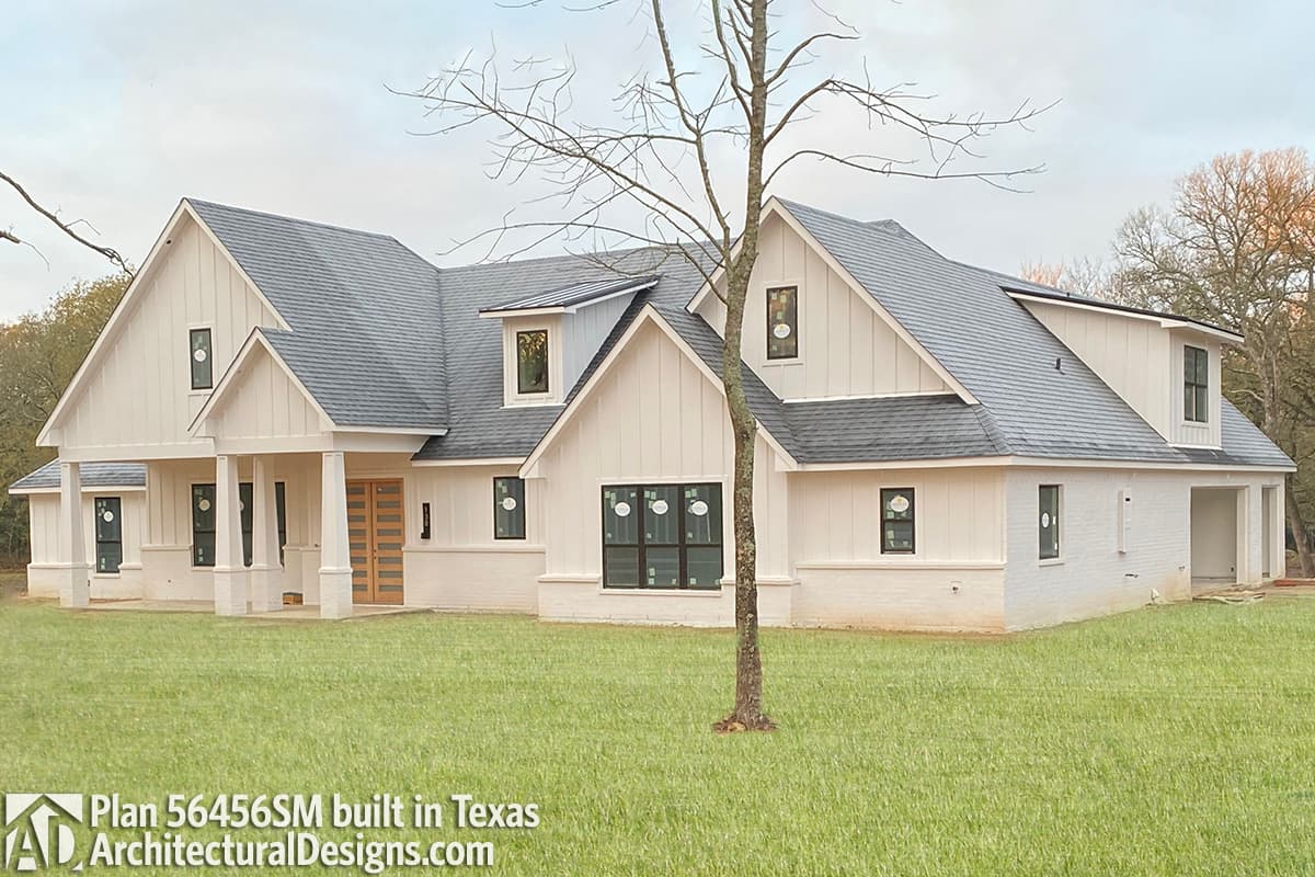 House plan exterior: Modern Farmhouse style, two stories, white board and batten siding, gables, dormers, and attached garage.