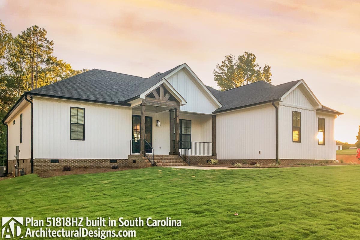 Modern Farmhouse house plan exterior with board and batten siding, covered entry with timber accents, and brick foundation.