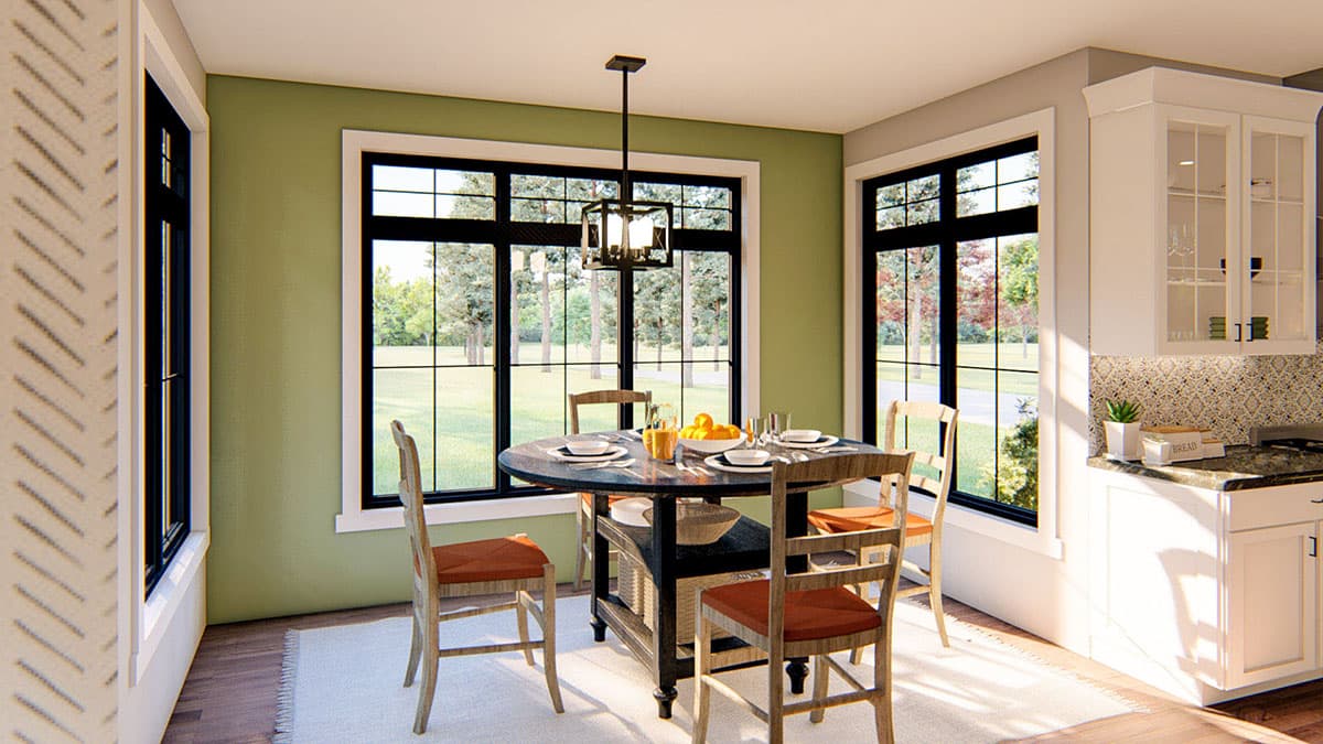Dining area with round table, chairs, and large grid windows. Kitchen cabinetry visible.