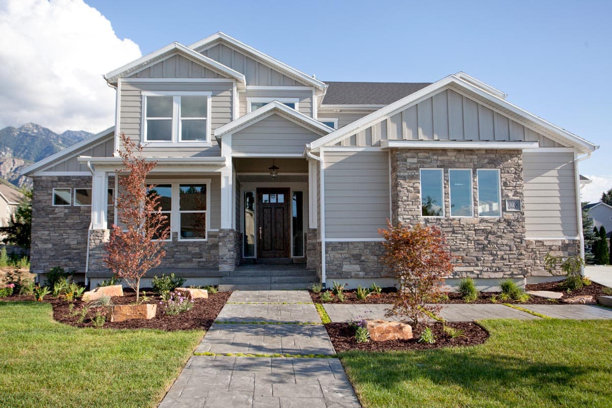 House plan exterior with stone accents, two stories, gabled roof, and a covered front porch.