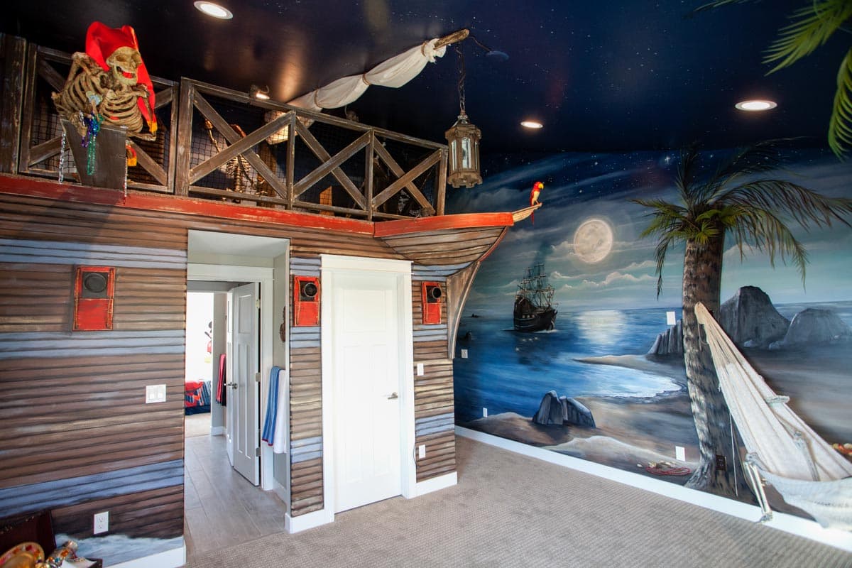 Interior room with pirate ship theme. Features a lofted area, ship's bow design, and a mural of a ship at sea.